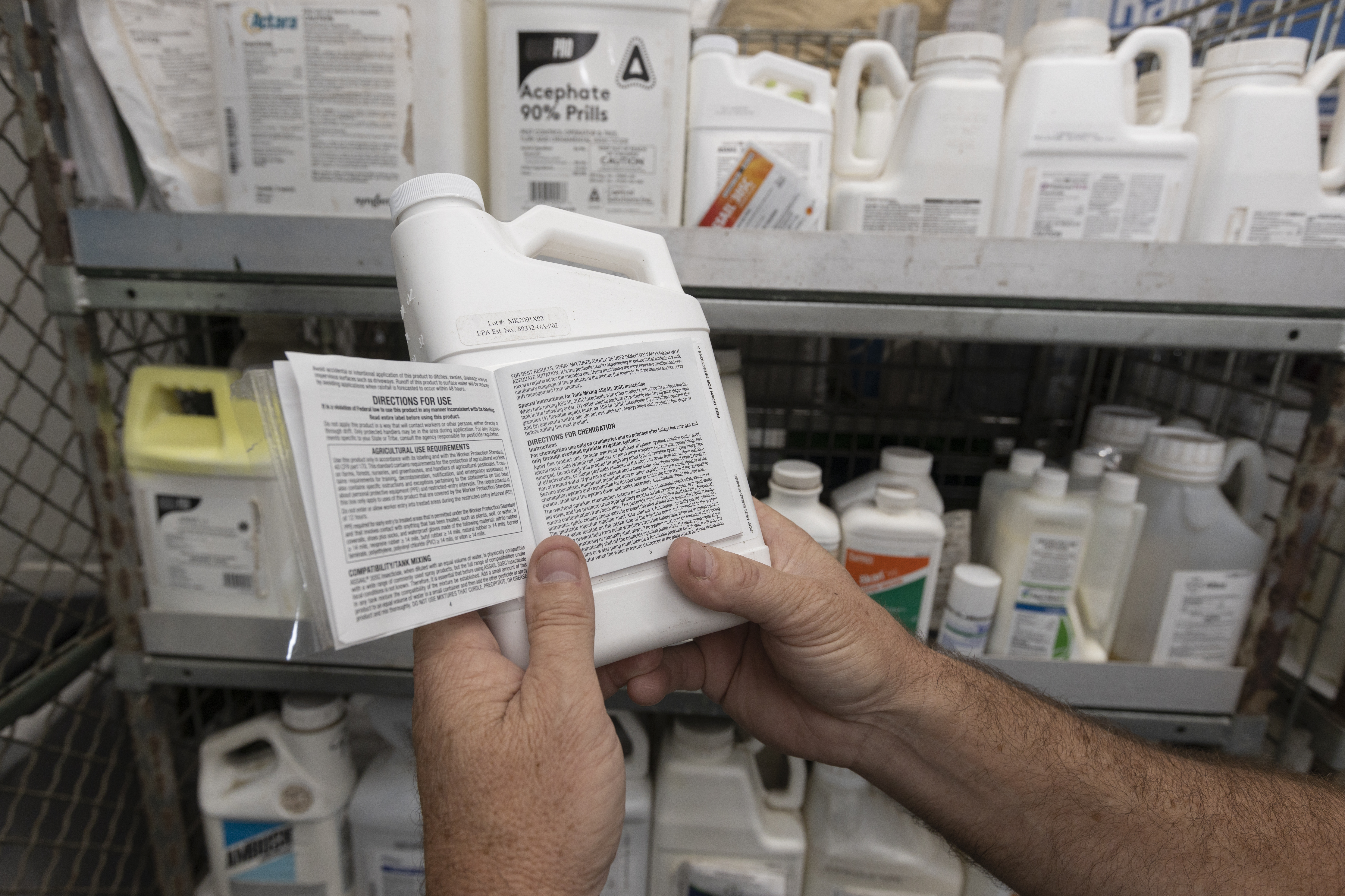 Person reading a pesticide label in front of them.